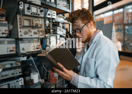 Seltsame Ingenieur mit Buch, Test im Labor Stockfoto