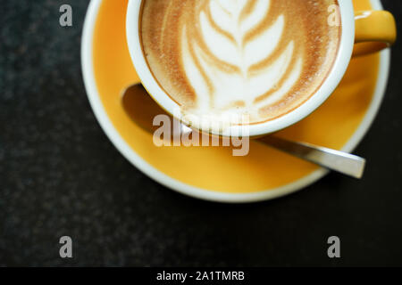 Kaffee Latte Blatt Muster auf schwarz Tabelle Stockfoto