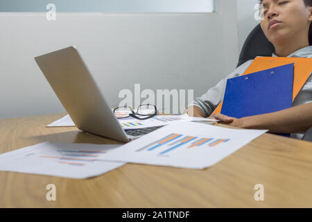 Erschöpft manager Einschlafen beim Lesen der Berichte Stockfoto