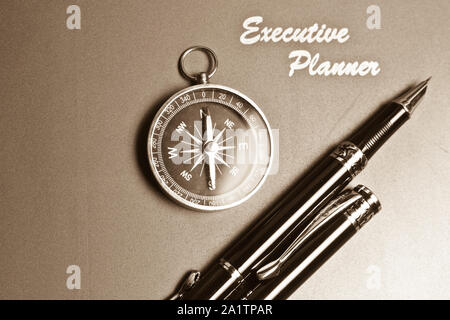 Ein Executive Planer mit einfachen Kompass und zwei Stifte in sepia Ton Stockfoto