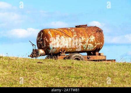Alten verrosteten Wassertank stehen auf der Weide. Wasser für das Vieh. Trockene Sommer. Trinkwasserversorgung. Stockfoto