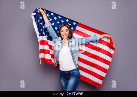 Niedlich süß schön aufgeregt lächelnde Dame abgewanderte Arbeitnehmer Holding USA american flag hinter Rücken, über grauer Hintergrund Stockfoto