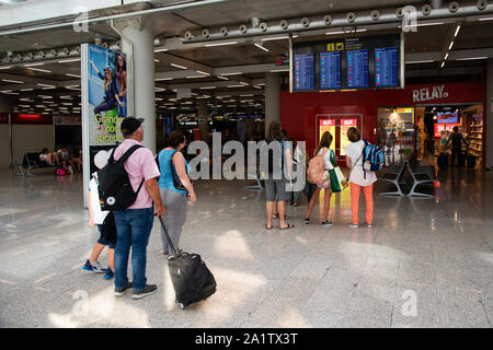 Mallorca, Spanien, 20. August 2019: Fluggäste beobachten, Zeitpläne und Richtungen auf boarding Boards am Flughafen Palma de Mallorca Stockfoto