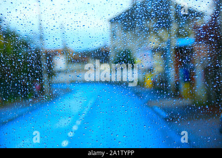 Regen außerhalb Fenster auf Stadt Hintergrund. Tropfen Wasser fällt auf Glas bei Regen. Wassertropfen über Fenster Glas während es regnete. Regen in ci Stockfoto