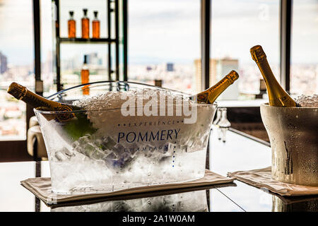 Champagner-Eimer mit der Aufschrift "Pommery" und gekühlte Flaschen stehen auf der Theke der Hotelbar hoch über Tokio im The Okura Tokyo, Minato-ku, Japan. Stockfoto