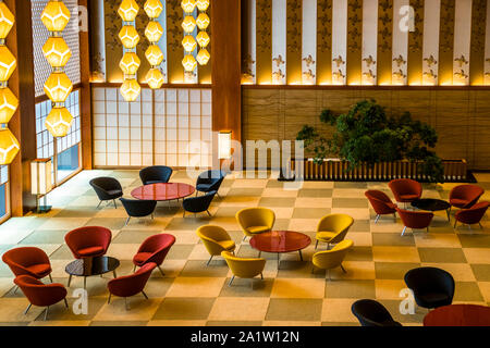 Interieur des Okura Hotels in Tokio, Japan. Die Sitzgruppen sind in Form von Pflaumenblüten angeordnet. Die Möbel sind Repliken, aber die Anordnung um die Lacktische und auf dem Schachbrettmuster des Teppichs entspricht dem Design von 1962. Grundsätzlich wird den Gästen in diesem Bereich auch heute noch nichts serviert Stockfoto