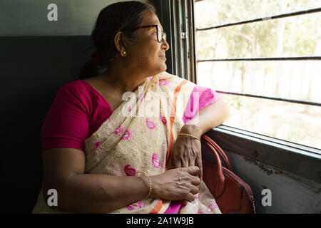 Eine indische Frau ist Blick aus dem Fenster eines indischen Zug, wie sie von Delhi nach Varanasi reist. Stockfoto