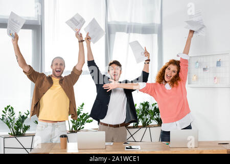 Drei lächeln Freunde holding Papiere und Kamera Stockfoto