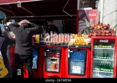 Istanbul, Türkei, März 08,2019: Kunde mit den Händen auf seinen Kopf im vorderen Ladenbereich mit frischen Früchten und Kühlschränke mit Saft und Wasser an einem sonnigen Tag Stockfoto