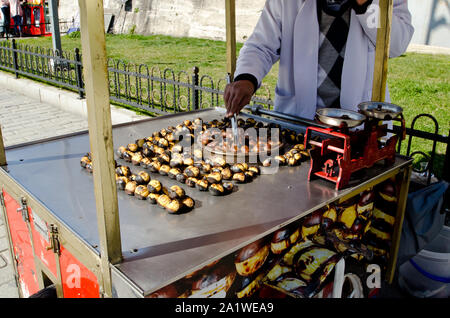 Straßenhändler verkaufen gerösteten Kastanien in der Tradition Street Food Warenkorb, bis an einem sonnigen Tag schließen, Straße von Istanbul Stockfoto