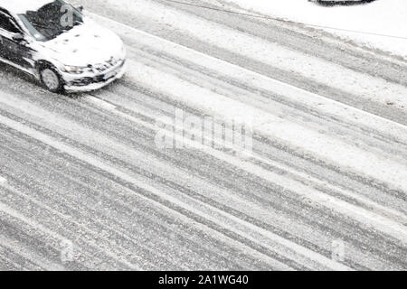 Blurry Auto auf der leeren Straße der Stadt während einer Schneefall Stockfoto