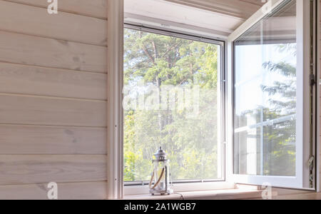 Weißes Fenster mit Moskitonetz in einem rustikalen Holzhaus mit Blick auf den Garten, geringe Tiefenschärfe Stockfoto