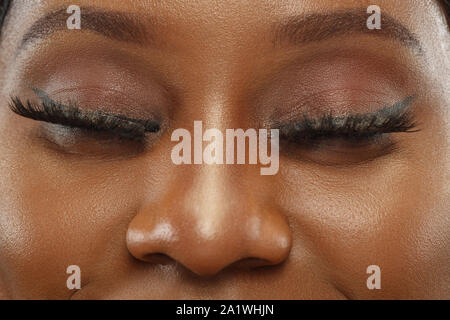 African-american junge Frau close up Portrait. Schöne weibliche Modell im weißen Hemd mit gepflegte Haut. Menschliche Gefühle, Mimik, Schönheit. Ruhig, zuversichtlich. Augen mit Tief braune Farbe. Stockfoto