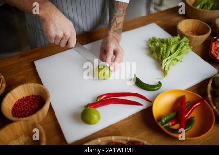 Nahaufnahme des unkenntlich Koch schneiden Limonen und hot pepper beim Kochen pikante asiatische Essen im Restaurant Küche, Kopie Raum Stockfoto