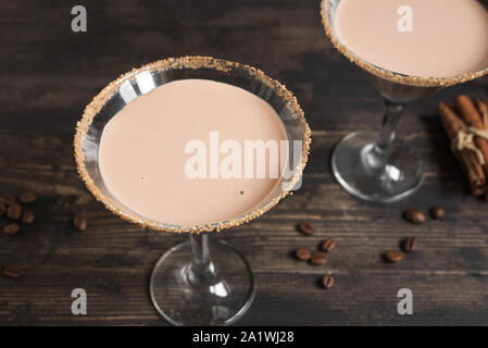 Kaffee Martini Cocktail oder Irish Cream Likör in Gläsern auf rustikalen Holzmöbeln Hintergrund. Stockfoto