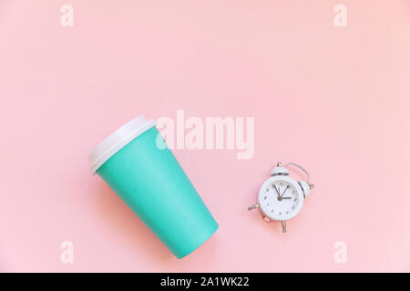 Einfach flach Design blaues Papier Kaffeetasse und Wecker auf rosa Pastell bunten Hintergrund isoliert. Takeaway trinken Frühstück trinken. Guten Morgen aufwachen wach Konzept. Ansicht von oben kopieren Raum Stockfoto