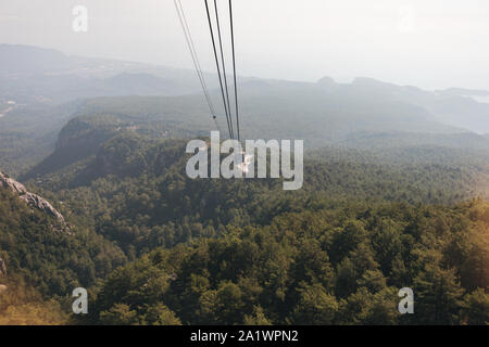 Blick auf die Berge von der Kabine mit der Seilbahn auf die Spitze des Tahtali und das Meer in der Nähe der Küste von Kemer, Antalya, Türkei Stockfoto