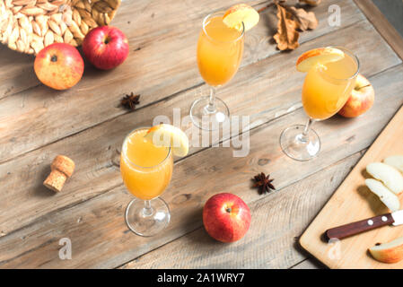 Apple Mimosa Cocktail in hohe Gläser und organische Äpfel auf Holz. Saisonale fallen Getränke für Ferienwohnung Mimosa Champagner Cocktail mit Äpfeln. Stockfoto