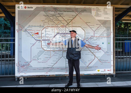 Ältere männliche Touristen steht vor der Berliner BVG-Karte. Karte von S-Bahn, U-Bahn und die Straßenbahnen in Berlin, Deutschland Stockfoto