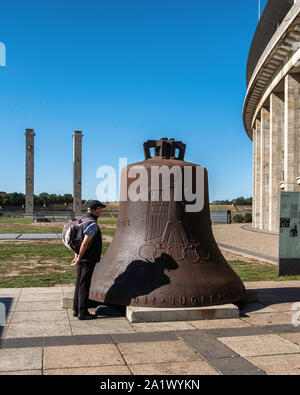 Berlin, Olympiastadion Grundstück. Hohe Türme und beschädigte Olympic Glocke aus dem Glockenturm ist mit olympischen Ringen, einen Adler, das Jahr 1936 eingeschrieben Stockfoto