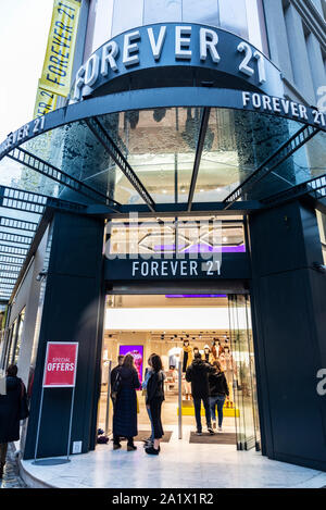 Athen, Griechenland - Januar 4, 2019: Anzeige eines Für Immer 21 Store bei Nacht mit Menschen um in Athen, Griechenland Stockfoto