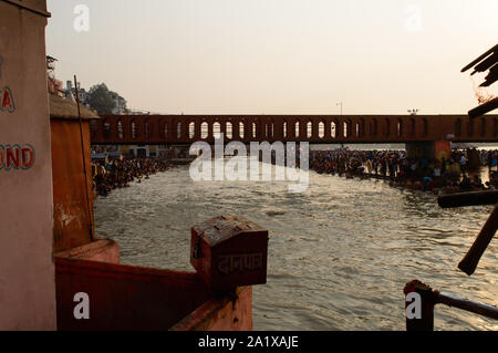 Schwere Masse, Badewanne in Ganga Fluss durch Festival in Haridwar Brücke Tempel Himmel saavan zu nehmen. Stockfoto