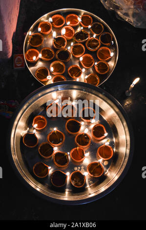 Eine Platte, die mit rose geladen und Kerze auf indischen Festival diwali deepawali mit Feuer am Tisch isoliert Stockfoto