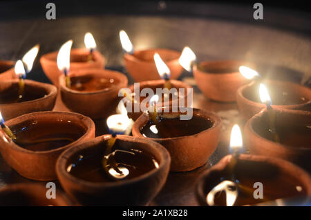 Eine Platte, die mit rose geladen und Kerze auf indischen Festival diwali deepawali mit Feuer am Tisch isoliert Stockfoto