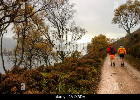 Wanderer zu Fuß auf dem Weg um Loch Muick in Aberdeenshire, Schottland, Großbritannien Stockfoto