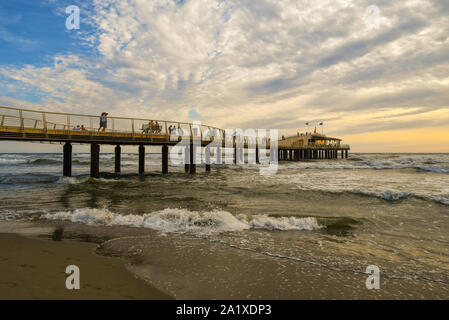 Blick auf pontile Bellavista Vittoria, ein modernes Pier in 2008 gebaut, mit Touristen zu Fuß bei Sonnenuntergang im Sommer, Lido di Camaiore, Toskana, Versilia, Italien Stockfoto