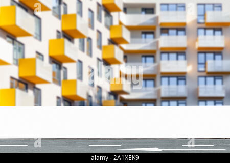 Weiße leere Bauzaun mockup mit modernen Wohngebäude in verschwommenen Hintergrund, horten Panel mit Kopie Raum für Branding oder Gebäude Stockfoto