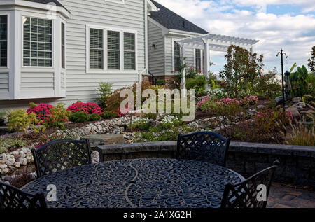 Garten, Blumen, Pflanzen, Pergola, Steine, schmiedeeiserne Tische & Stühle, Haus, Landschaftsgarten, Stein Terrasse; Virginia; Horizontal; PR Stockfoto