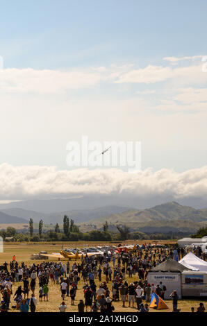 Airshow Masse an Flügel über Wairarapa air show an Haube Flugplatz, Masterton, Wairarapa, Neuseeland. Land, Hügel, Menschen und Flugzeuge Stockfoto