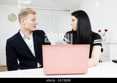 Vorgesetzten arbeitet mit unterordnen. Blonder Mann mit schwarzen behaarte Frau, emotional diskutieren Stockfoto