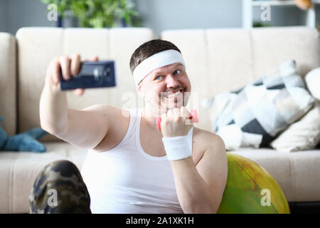 Lächelnd Sportler unter Foto auf Handy Stockfoto