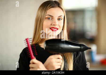 Mädchen Friseur kreuzte die Hände mit Kamm und Trockner Stockfoto