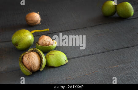 Walnüsse in einer grünen Shell auf einem Holztisch Stockfoto