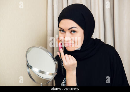 Schöne muslimische Frau Wimperntusche auftragen. Junge arabische Frau mit Bürste verzurren. Stockfoto