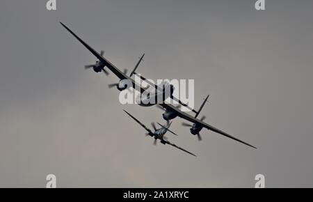 Die Schlacht um England Memorial Flight (BBMF) Avro Lancaster (PA474) im Formationsflug mit Supermarine Spitfire (PM631) in Duxford am 22. September 2019 Stockfoto