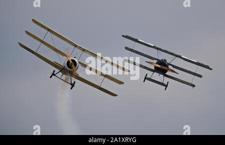 Große Krieg Display Team - Sopwith Dreidecker und Fokker Dr1 Dreidecker Durchführen einer WW1 Dogfight reenactment in der Schlacht von Großbritannien 2019 Duxford Airshow Stockfoto