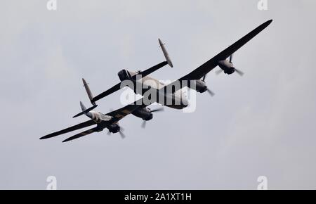 Die Schlacht um England Memorial Flight (BBMF) Avro Lancaster (PA474) im Formationsflug mit Supermarine Spitfire (PM631) in Duxford am 22. September 2019 Stockfoto