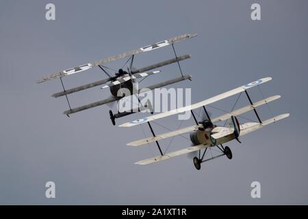 Große Krieg Display Team - Sopwith Dreidecker und Fokker Dr1 Dreidecker Durchführen einer WW1 Dogfight reenactment in der Schlacht von Großbritannien 2019 Duxford Airshow Stockfoto