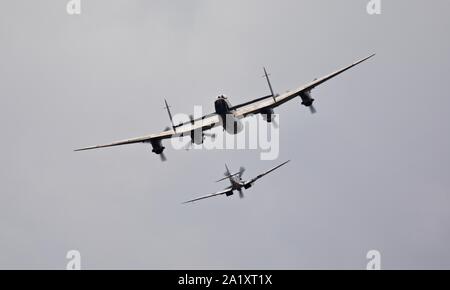 Die Schlacht um England Memorial Flight (BBMF) Avro Lancaster (PA474) im Formationsflug mit Supermarine Spitfire (PM631) in Duxford am 22. September 2019 Stockfoto