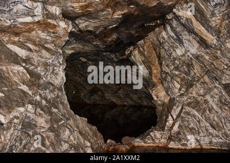 Eine Höhle in einem ehemaligen unterirdischen Steinbruch. Braun Natur Marmor und seine Textur sichtbar sind. Russland, Karelien, Ruskeala Mountain Park. Höhle in Marmor Stockfoto