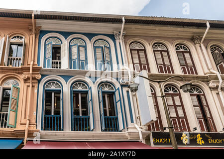 Singapur - 22. März 2019: Chinatown. Nahaufnahme der bemalten Fassaden in Sago Straße zeigt verschiedene Farben, offene und geschlossene Fenster mit Fensterläden aus Holz. Stockfoto