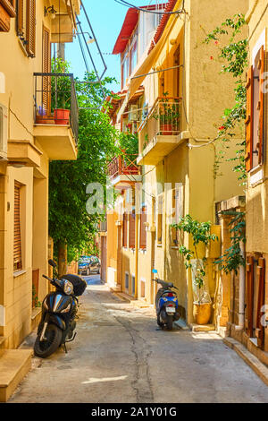 Bunte gemütliche griechische Straße mit abgestellten Motorroller an sonnigen Sommertag in Ägina Stadt Aegina Island, Griechenland Stockfoto