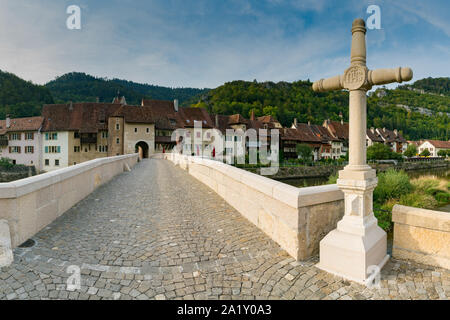 Saint-Ursanne, Jura/Schweiz - vom 27. August 2019: historische Steinbrücke führt zum Tor und malerischen Dorf Saint-Ursanne Stockfoto