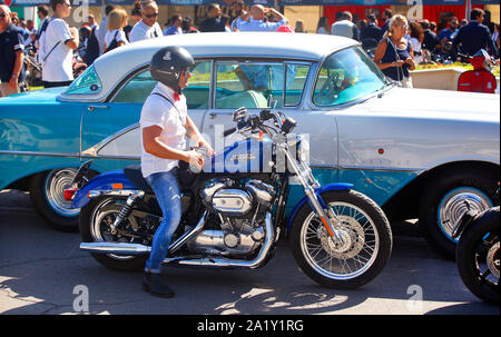 Die Teilnehmer der 2019 Distinguished Gentlemen's Ride versammeln sich in Pescara, Italien. Harley Davidson 883 Sporster neben einem 50er Oldsmobile Urlaub. Stockfoto