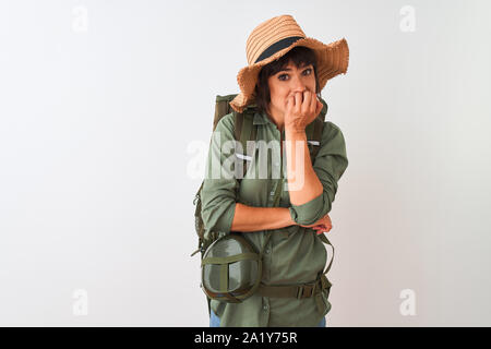 Wanderer Frau mit Rucksack, Hut und Wasser Kantine über isoliert weißer Hintergrund auf der Suche gestresst und nervös mit den Händen auf den Mund Beißen Nägel. Anxie Stockfoto