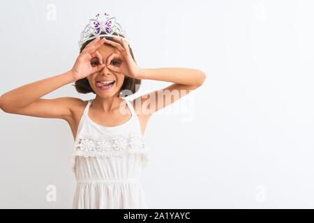 Schönes kind Mädchen mit Princess Crown stehend über isoliert weißer Hintergrund tun ok Geste wie Fernglas Zunge heraus, Augen Stockfoto